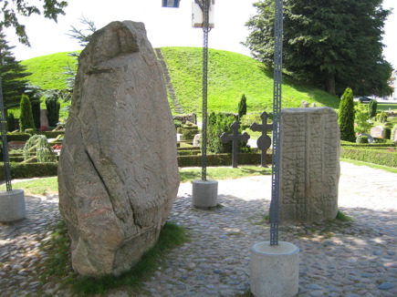 Church in Jelling with rune stones in front of the church door Church in Jelling with rune stones in front of the church door
